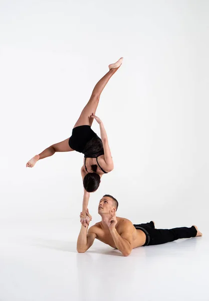 Two athletes performing duo acroyoga poses Stock Photo by Photology75