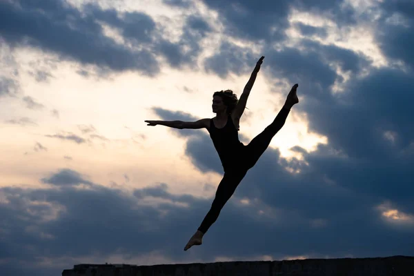 Joven bailarina saltando sobre el fondo al aire libre del amanecer. Concepto de libertad y estilo de vida feliz — Foto de Stock