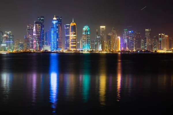 Vibrante horizonte de Doha por la noche visto desde el lado opuesto de la bahía de la capital por la noche — Foto de Stock