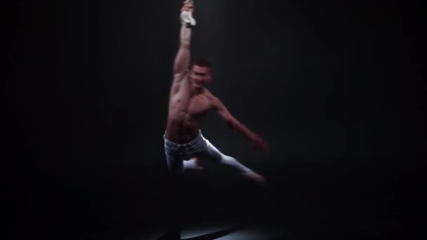Aerialista de circo muscular en las correas aéreas en estudio negro — Vídeos de Stock