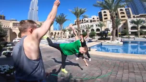 Группа акробатов прыгает с двойной скакалкой в Дубае, выполняя различные трюки в замедленной съемке — стоковое видео