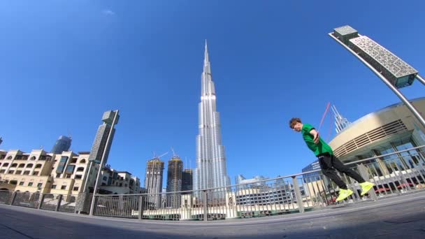 Hombre saltando con la cuerda de salto en el fondo del paisaje urbano de Dubai. Movimiento lento — Vídeo de stock