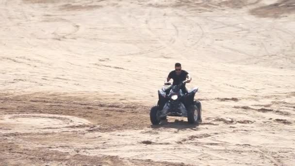 スローモーションで砂漠でAtvに乗る筋肉マン — ストック動画