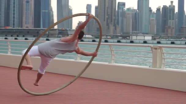 Cyr Wheel artist i slow motion med stadsbild bakgrund i Dubai under soluppgången — Stockvideo