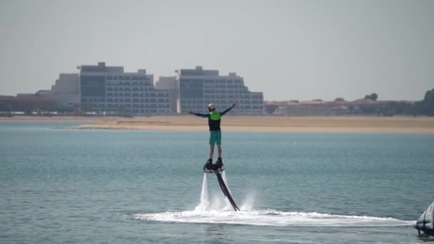 El principiante está aprendiendo a manejar en el flyboard acuático. Descanso extremo en el mar — Vídeo de stock