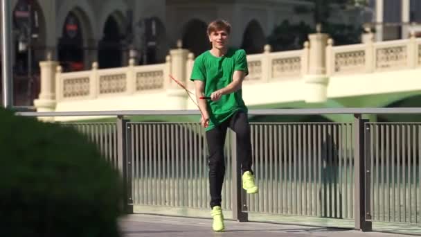 Uomo che salta con corda di salto sullo sfondo paesaggio urbano di Dubai. Rallentatore — Video Stock