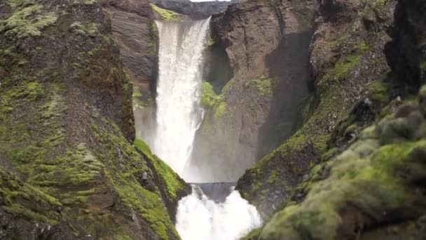 아이슬란드 의아름다운 완만 한 폭포 가 낮에 천천히 움직 이는 등산 로를 따라 달리고 있다 — 비디오