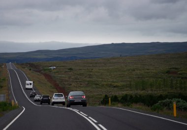 Kırsal kesimde bir kaç araba yolda. İzlanda