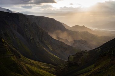 Thorsmork yakınlarındaki Fimmvorduhals yürüyüş yolunda dramatik ve renkli günbatımında Kanyon ve Dağ zirvesi