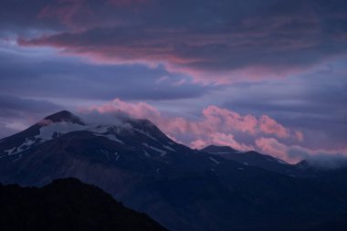 Thorsmork yakınlarındaki Laugavegur Yürüyüş yolunda dramatik ve renkli günbatımında kar ve bulutlarla dolu dağ zirvesi