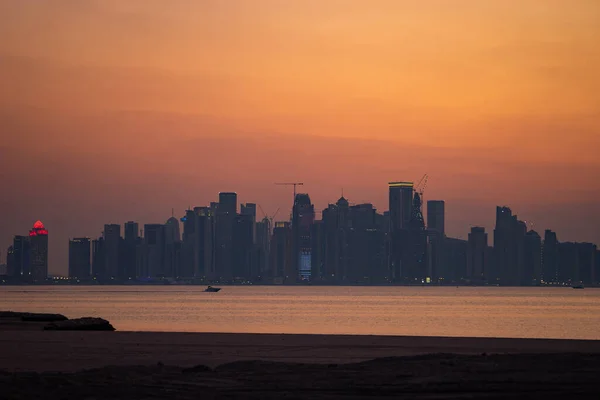 Vibrante horizonte de Doha al atardecer dramático visto desde el lado opuesto de la bahía de la ciudad capital — Foto de Stock