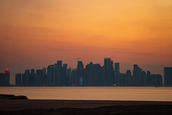 Vibrante horizonte de Doha al atardecer dramático visto desde el lado opuesto de la bahía de la ciudad capital — Foto de Stock