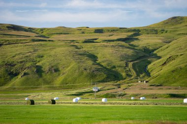 Yeşil tarladaki çim yığınları güzel yeşil tepeler ve arka planda gökyüzü