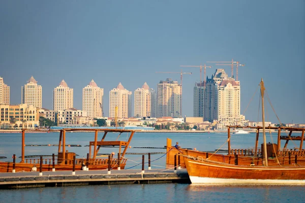 Traditional fishing boat At docked with city on background at long berth with calm blue water — Stock Photo, Image