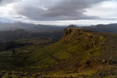 Thorsmork yakınlarındaki Fimmvorduhals yürüyüş yolunda dramatik ve renkli günbatımında Kanyon ve Dağ zirvesi