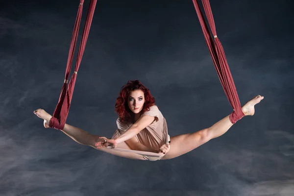 Artiste de cirque aérienne féminine athlétique, sexy et flexible avec rousse dansant en l'air sur la soie — Photo