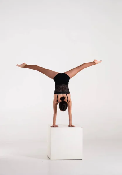 Hombre de buena forma mujer practicando soporte de mano en cubo blanco aislado sobre fondo blanco. Fuerza y motivación — Foto de Stock