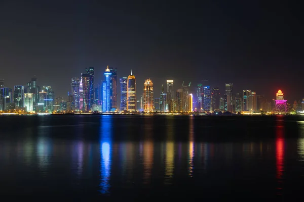 Vibrante horizonte de Doha por la noche visto desde el lado opuesto de la bahía de la capital por la noche — Foto de Stock
