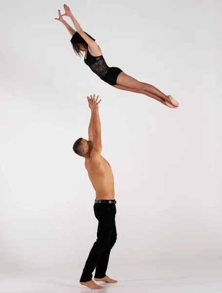 Kaslı adamın kadınları havaya atması. Beyazın üstünde izole edilmiş olarak. Güven, güç ve cesaret kavramı 
