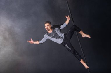 Performans konsepti. Çin direğinde asılı bir adam. Atlet uçan direği oynuyor