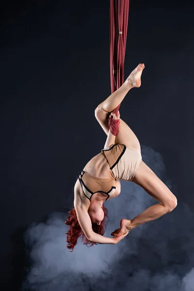 Kvinnlig atletisk, sexig och flexibel antenn cirkusartist med rödhårig dansar i luften på siden — Stockfoto