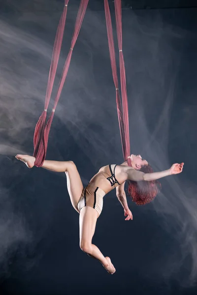 Жіночий спортивний, сексуальний і гнучкий артист повітряного цирку з рудим танцем в повітрі на шовку — стокове фото