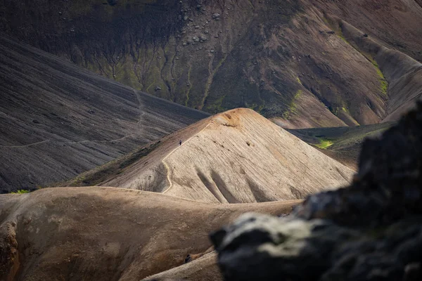 Landmannalaugar Colina colorida sobre fondo de ceniza negra en el sendero de senderismo Laugavegur. Islandia. La combinación de capas de rocas multicolores, minerales — Foto de Stock