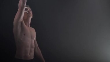 Sirk erkek kaslı sanatçısı siyah arka planda küp aksesuarlarıyla hokkabazlık yapıyor. Konsantrasyon, kontrol, güç ve güç kavramı