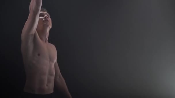 Ein muskulöser Zirkuskünstler, der Kunststücke mit Jonglierwürfeln vor schwarzem Hintergrund vollführt. Konzeption von Konzentration, Kontrolle, Kraft und Macht — Stockvideo