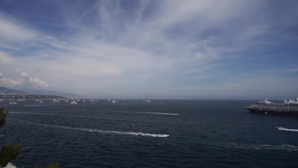 Monte Carlo, Μονακό, Ιουλ 2019. Κρουαζιερόπλοια στη θάλασσα κατά τη διάρκεια της ηλιόλουστης ημέρας που περιβάλλεται από πολλά powerboats. Μόντε Κάρλο, Μονακό. — Αρχείο Βίντεο