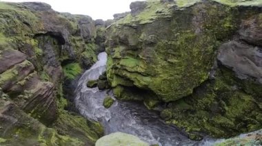 İzlanda 'daki kanyonda Fimmvorduhals yürüyüş pistinde yeşil uçurumlarla çevrili güzel bir nehir..