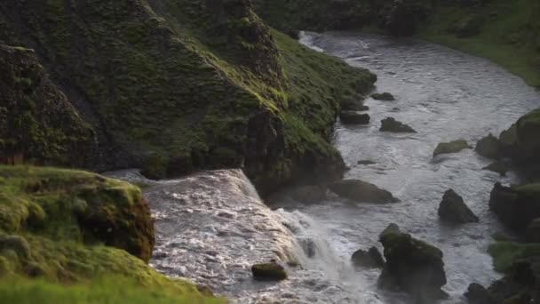 Movimiento lento del hermoso río suave en Islandia rodeado de verdes colinas durante la puesta de sol en el sendero de senderismo Fimmvorduhals cerca de Skogar — Vídeo de stock