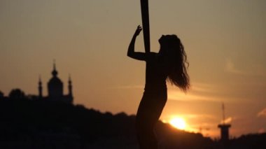 Kiev şehir arka planda bir gün batımı sırasında hava ipek üzerinde esnek bir kadın akrobat silueti. özgürlük ve barış kavramı
