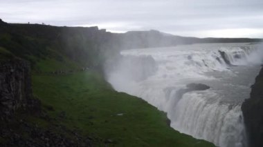 Bulutlu bir günde Gullfoss Şelalesi 'ne uzun bir turist kuyruğu. İzlanda. Yavaş Hareket