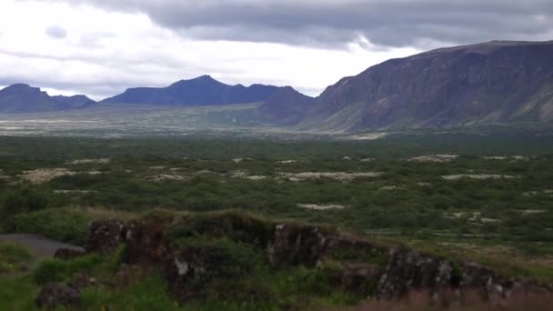 Όχημα που ταξιδεύει Ισλανδία ορεινή ακτογραμμή σκηνή μόνη της σε μοναχικό δρόμο κάτω από τραχύ σχηματισμό εδάφους — Αρχείο Βίντεο