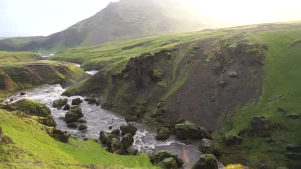 Rallentatore del bellissimo fiume liscio in Islanda circondato da verdi colline durante il tramonto sul sentiero escursionistico Fimmvorduhals vicino a Skogar — Video Stock