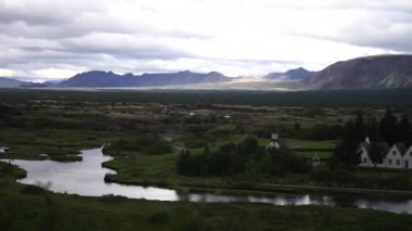 Oxara nehri İzlanda Ulusal Parkı Thingvellir 'de sonbahar günü, binalar kıyıda. Panorama