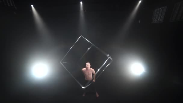 Цирк чоловічий м'язовий виконавець робить трюки з реквізитами для жонглювання кубиків на чорному тлі. Концепція концентрації, контролю, сили та влади — стокове відео