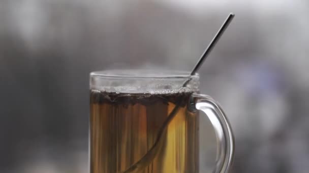 Taza de té caliente en el fondo nevado paisaje urbano de la luz del día — Vídeo de stock