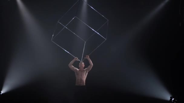 Цирковой мужчина мускулистый исполнитель делает трюки с жонглированием кубическим реквизитом на черном фоне. Концепция концентрации, контроля, силы и мощности — стоковое видео