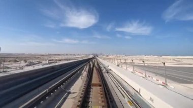Metro Treni, Doha Timelapse, Katar 'daki Al Wakra Metro İstasyonu' ndan dışarı çıkıyor..