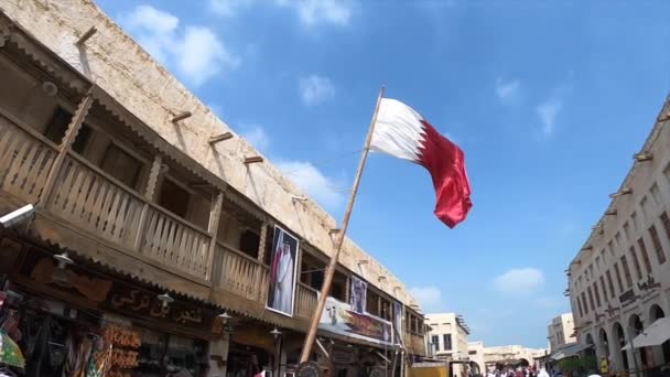 QATAR, DOHA, janeiro de 2020: Cidade velha em Souq Waqif Bandeira do Qatar em câmera lenta - bazar oriental em Doha — Vídeo de Stock