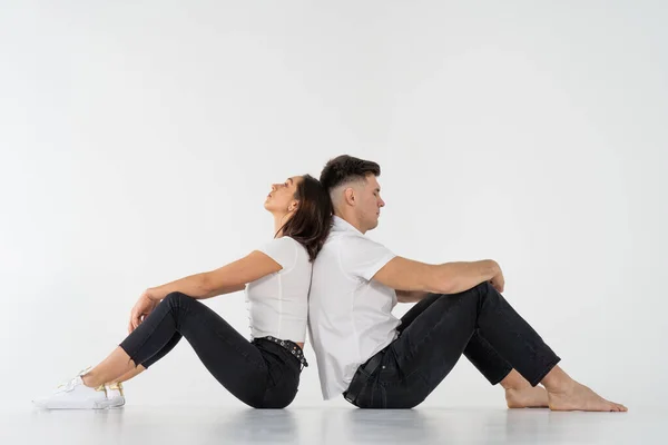 Homem e mulher pensativos sentados de costas para trás após a briga no fundo branco. espaço de cópia — Fotografia de Stock