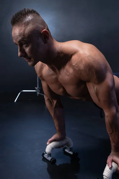 Hombre muscular haciendo ejercicio calisténico aislado sobre el fondo negro —  Fotos de Stock