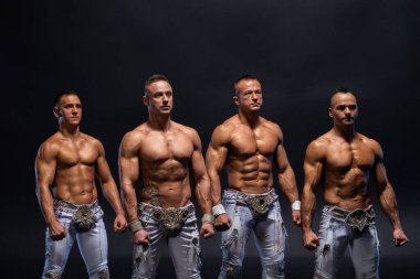 Siyah arka planda üstsüz duran dört kaslı adam. Sağlık, güç ve güç kavramı