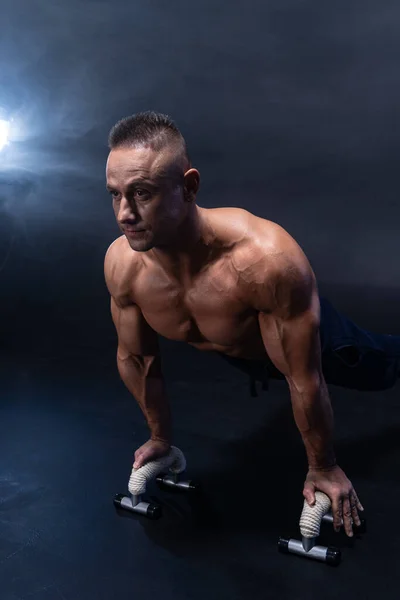 Hombre muscular haciendo ejercicio calisténico aislado sobre el fondo negro —  Fotos de Stock