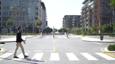 Megalopolis 'in modern bölgesinde yaya geçidini geçen kendine güvenen iş adamının yan görüntüsü