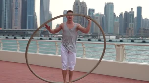 Cyr Wheel artiste au ralenti avec fond de paysage urbain de Dubaï pendant le lever du soleil — Video