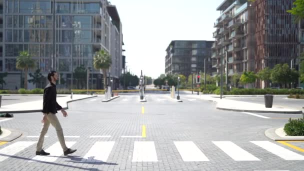 Side view of confident businessman passing crosswalk in modern district of megalopolis — Stock Video