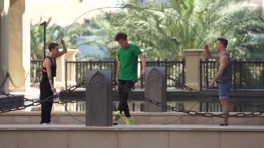 Dubai 'de çift atlama ipiyle atlayan bir grup akrobat yavaş çekimde farklı numaralar yapıyor.